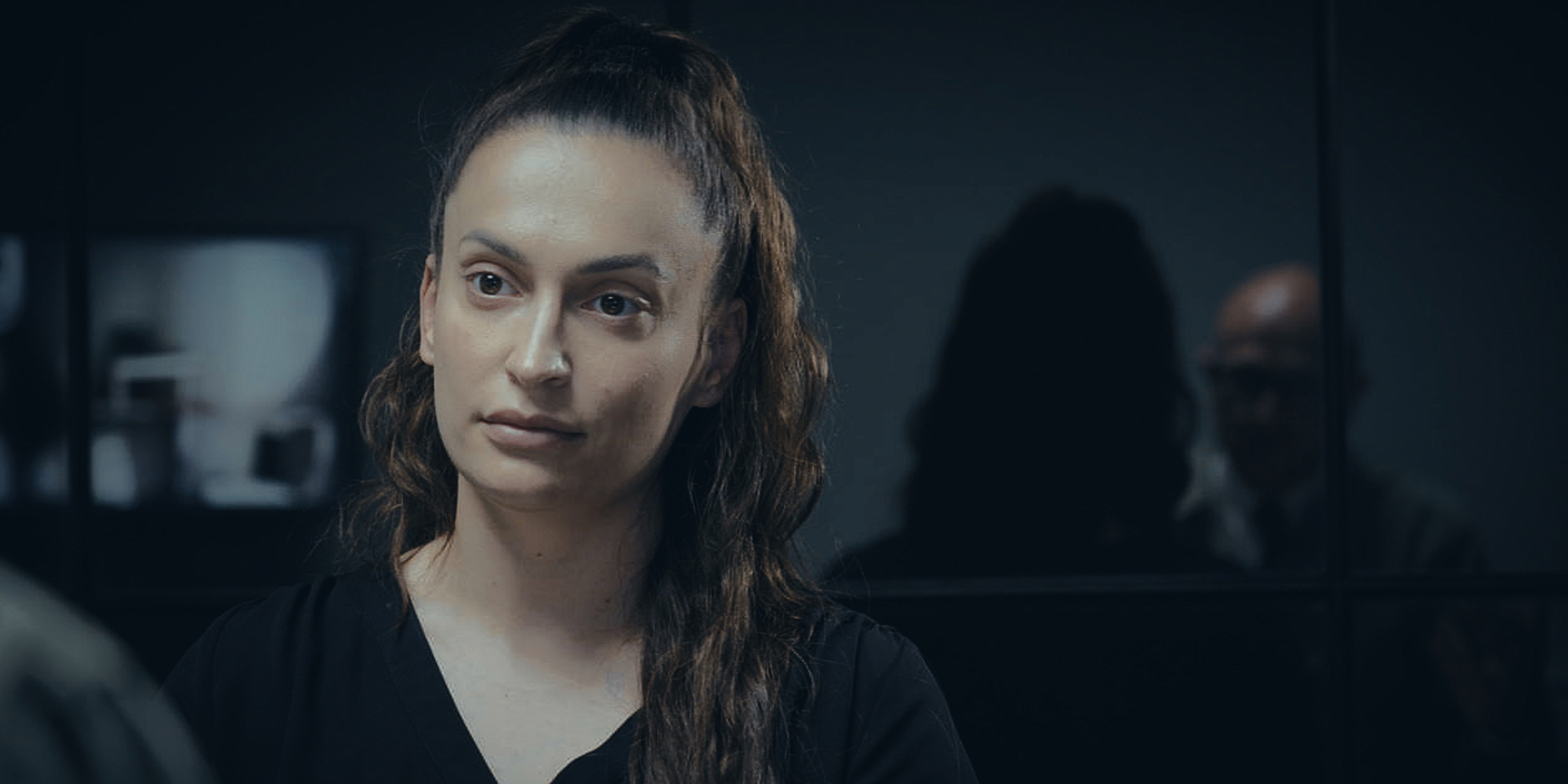 Kvinde i et mørkt rum under et interview